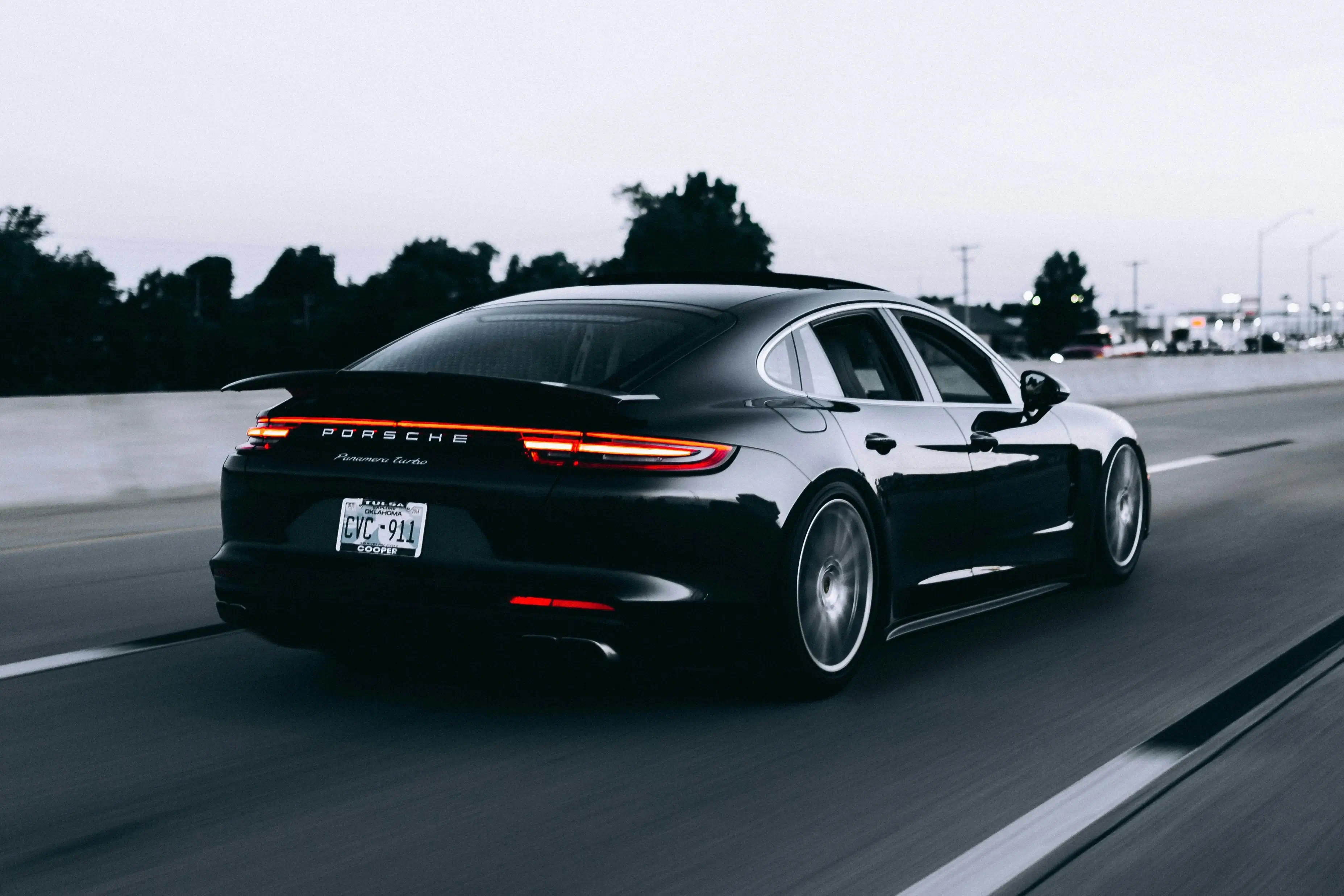 Black Porsche on the road at night